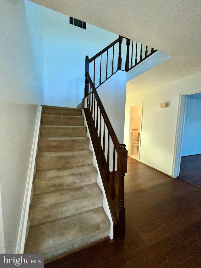 stairs featuring visible vents and wood finished floors