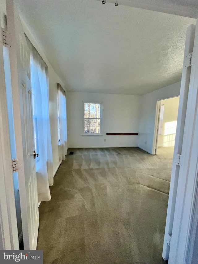 empty room with a textured ceiling and carpet