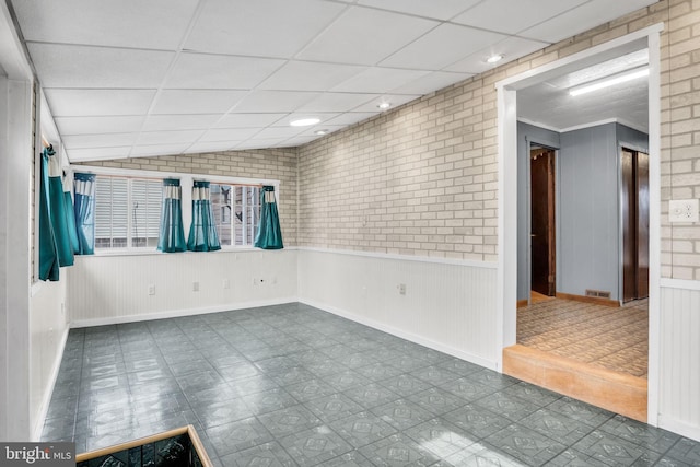 empty room with dark floors, wainscoting, a paneled ceiling, and lofted ceiling