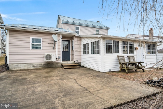 back of property featuring entry steps, a patio area, metal roof, and ac unit