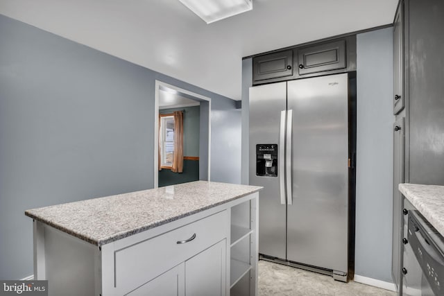 kitchen featuring appliances with stainless steel finishes, a kitchen island, and light stone countertops