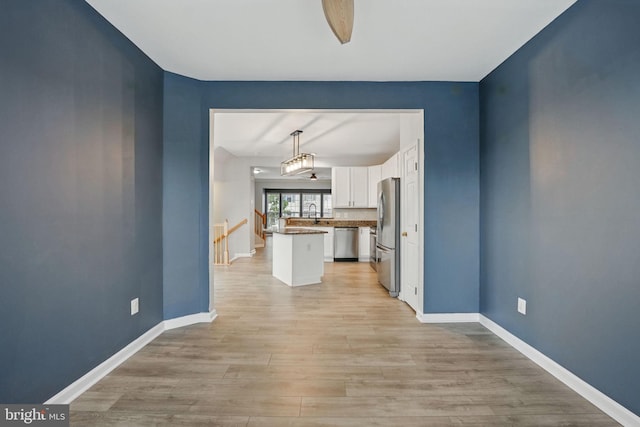 1332 Cranes Bill Way, Woodbridge, VA 22191 - unfurnished living room featuring light wood finished floors, baseboards, and a sink