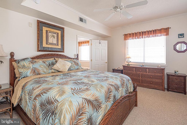 carpeted bedroom with ornamental molding, visible vents, and a ceiling fan