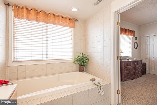 full bath featuring visible vents, a garden tub, and vanity