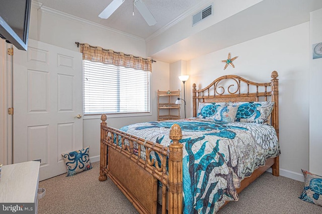 carpeted bedroom featuring baseboards, a ceiling fan, visible vents, and crown molding