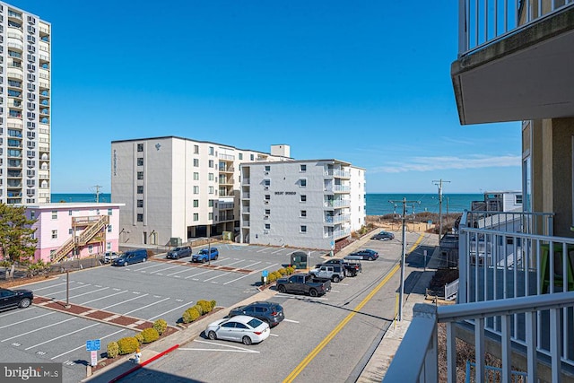 view of building exterior featuring uncovered parking and a water view