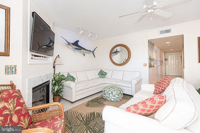 living room with crown molding, visible vents, a textured ceiling, and a high end fireplace