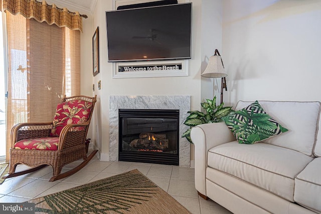 living area featuring tile patterned flooring, a fireplace, and ornamental molding