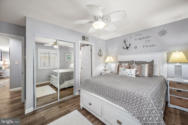 bedroom featuring dark wood-style floors, a closet, visible vents, and a ceiling fan