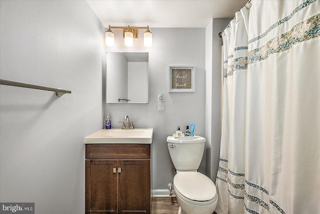 bathroom with curtained shower, baseboards, vanity, and toilet