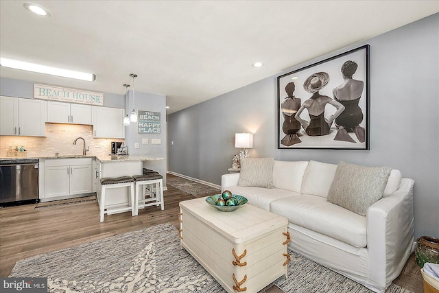 living area with recessed lighting, baseboards, and wood finished floors