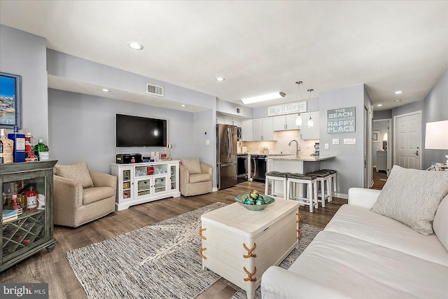 living room with recessed lighting, visible vents, and dark wood finished floors