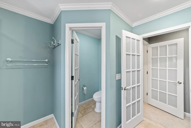 bathroom featuring french doors, baseboards, toilet, and ornamental molding