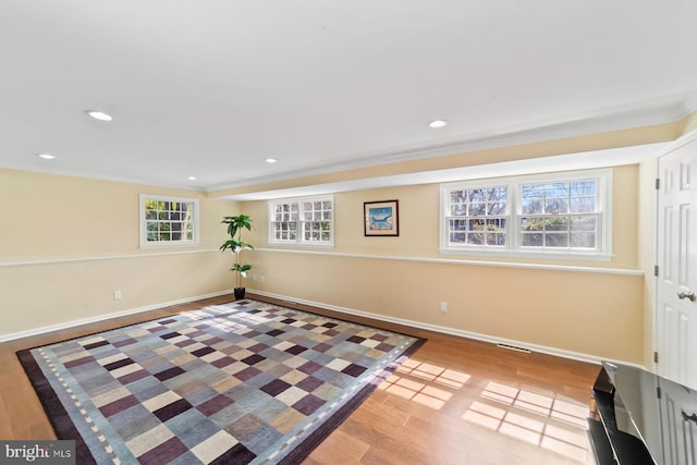 living area featuring recessed lighting, crown molding, baseboards, and wood finished floors