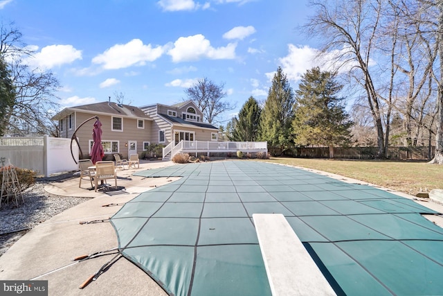 view of swimming pool with a deck, a patio, a fenced backyard, a yard, and a fenced in pool