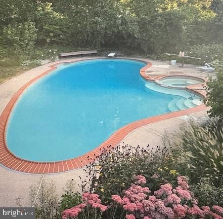 pool featuring an in ground hot tub