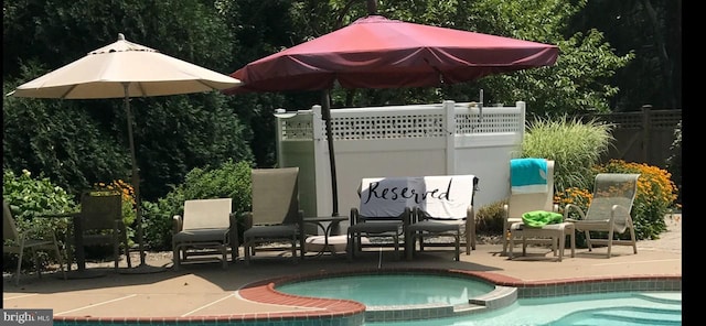 exterior space featuring fence and a pool with connected hot tub