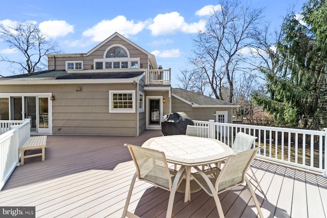 wooden deck with outdoor dining space and grilling area