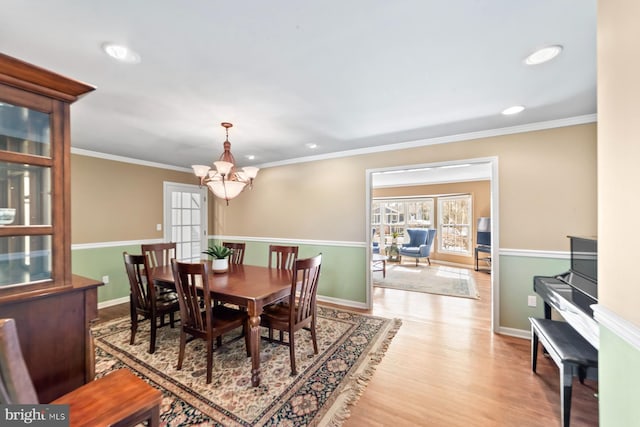 dining space featuring crown molding, baseboards, a chandelier, recessed lighting, and wood finished floors