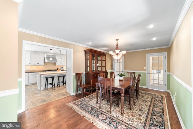 dining space with a notable chandelier, ornamental molding, recessed lighting, light wood-style floors, and baseboards