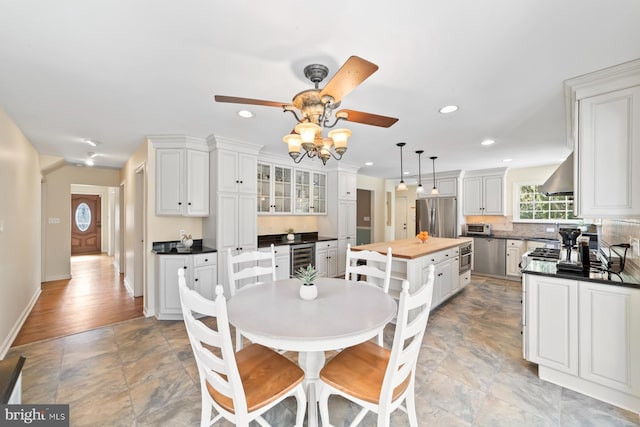 dining space with wine cooler, recessed lighting, baseboards, and ceiling fan