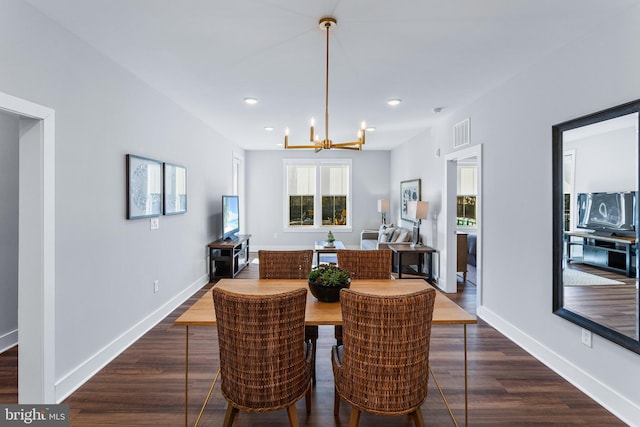 dining space with visible vents, dark wood finished floors, baseboards, and an inviting chandelier