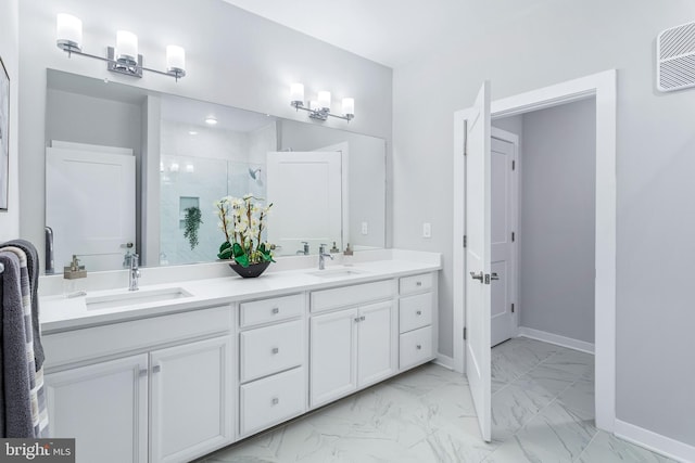 bathroom featuring a stall shower, marble finish floor, a sink, and baseboards