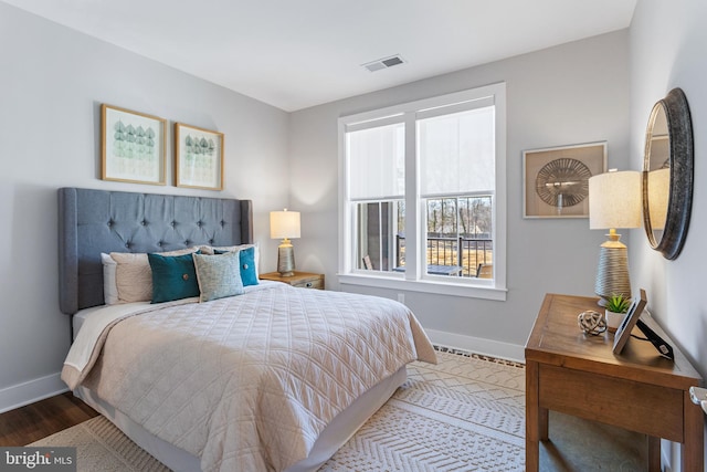 bedroom featuring wood finished floors, visible vents, and baseboards