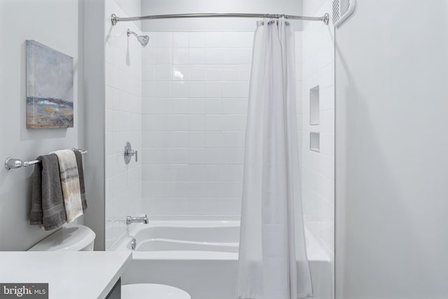 bathroom with toilet, shower / bath combo with shower curtain, and vanity