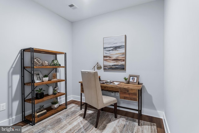 office featuring visible vents, baseboards, and wood finished floors