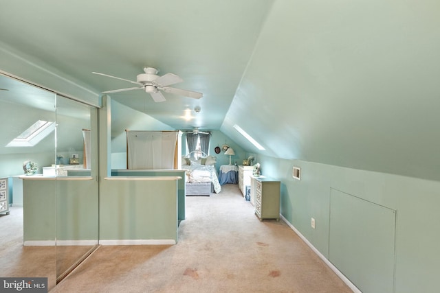 additional living space featuring lofted ceiling with skylight, carpet, visible vents, and a ceiling fan