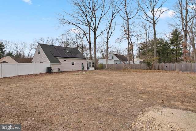 view of yard with a fenced backyard and central AC unit