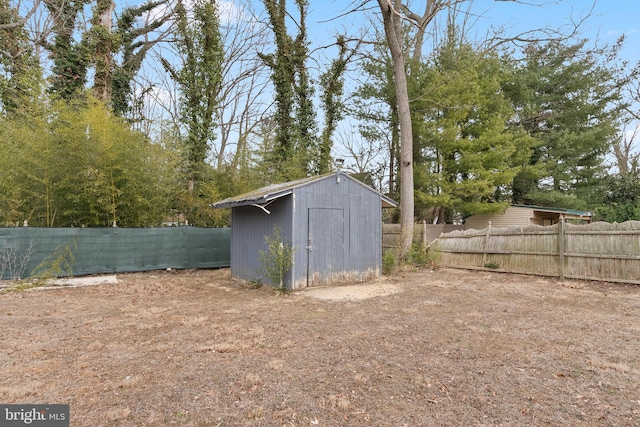 view of yard featuring a storage shed, an outbuilding, and a fenced backyard