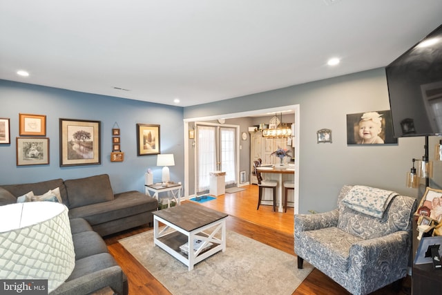 living area with visible vents, wood finished floors, and recessed lighting