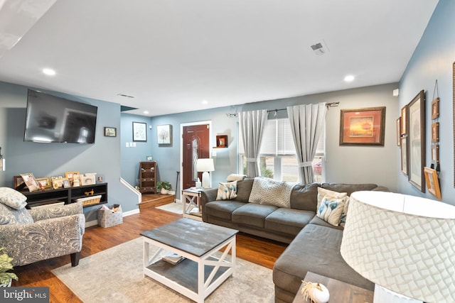 living area with visible vents, baseboards, wood finished floors, and recessed lighting