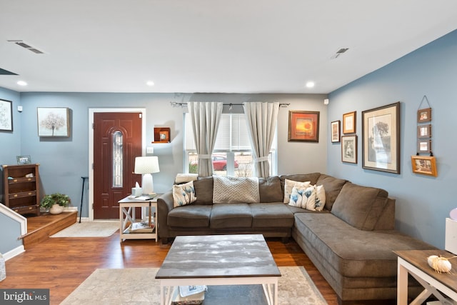 living room with wood finished floors, visible vents, and recessed lighting