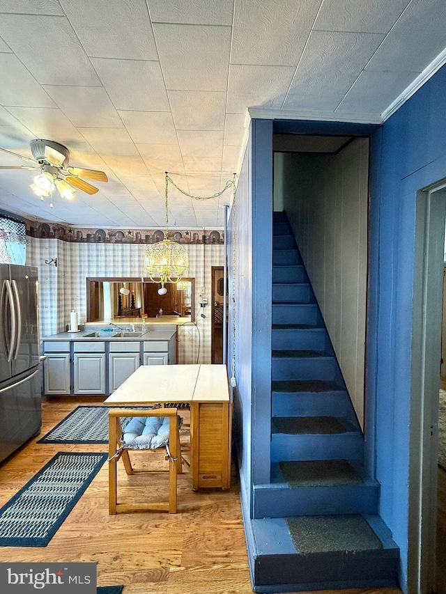 stairs featuring a ceiling fan and wood finished floors