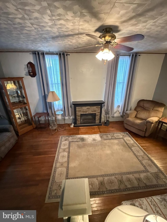 unfurnished living room featuring ceiling fan, a fireplace, and wood finished floors