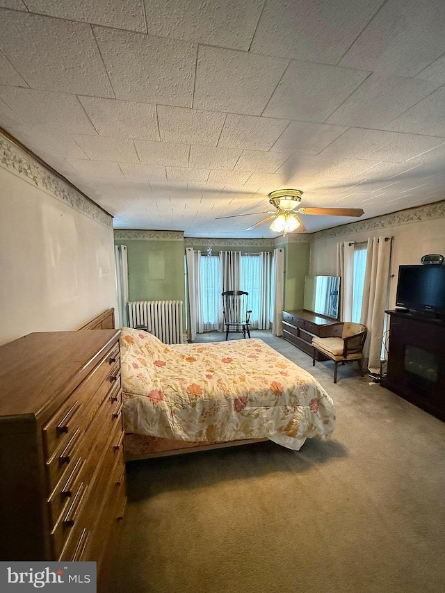 unfurnished bedroom featuring a ceiling fan, carpet, multiple windows, and a fireplace