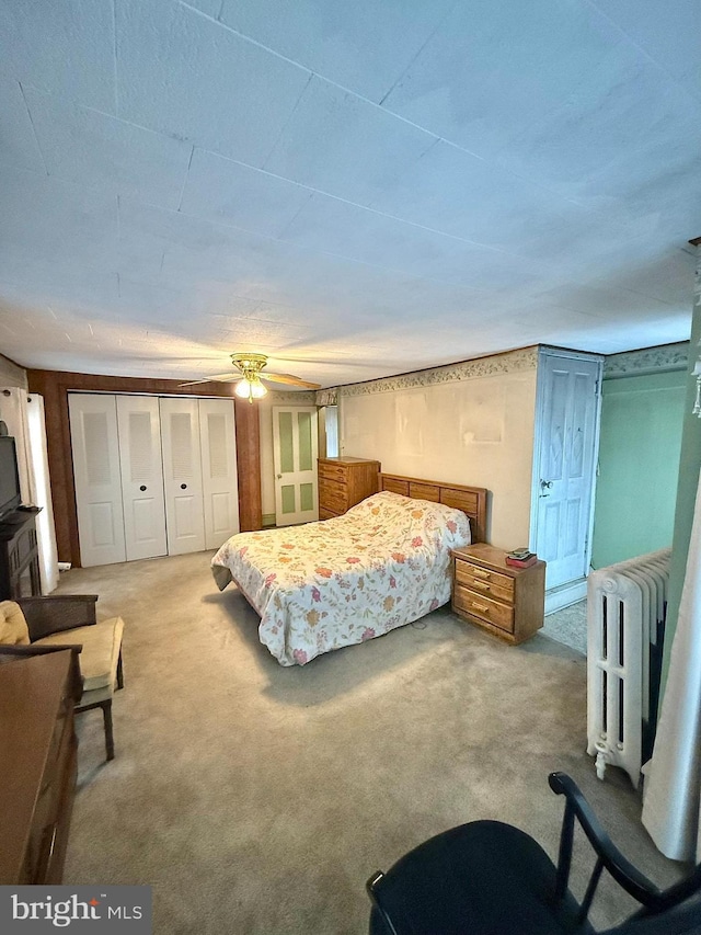 carpeted bedroom with ceiling fan and radiator heating unit