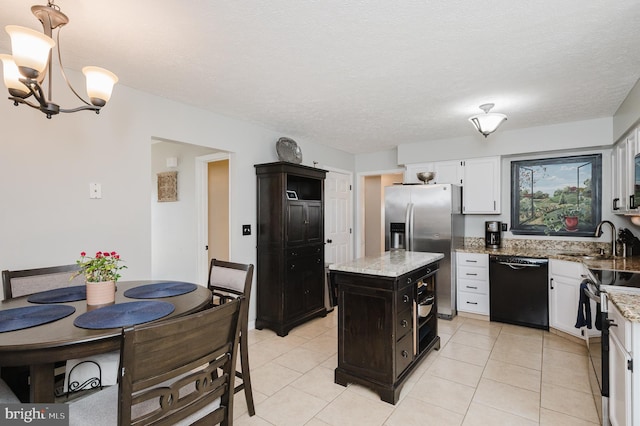 kitchen featuring light stone countertops, white cabinetry, appliances with stainless steel finishes, and a sink