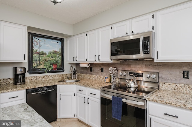 kitchen featuring stainless steel appliances, a sink, and light stone countertops