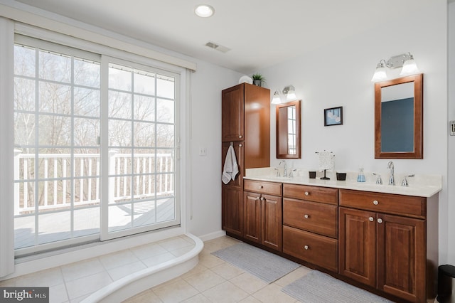 full bath with double vanity, tile patterned flooring, visible vents, and a sink