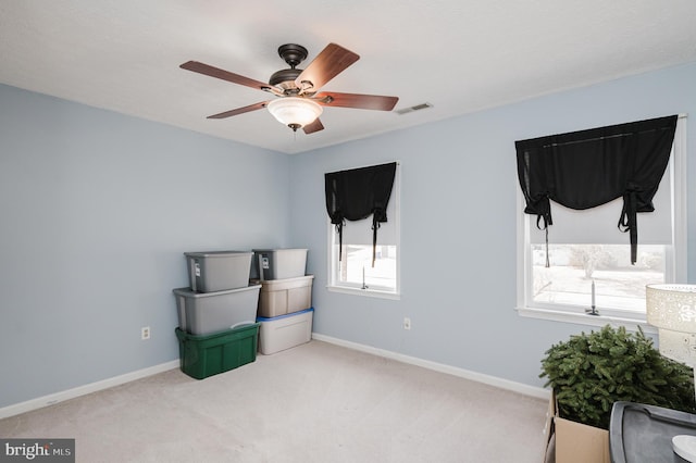 interior space featuring carpet floors, a healthy amount of sunlight, visible vents, and baseboards