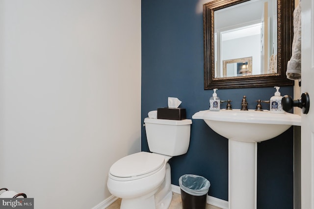 bathroom with baseboards and toilet