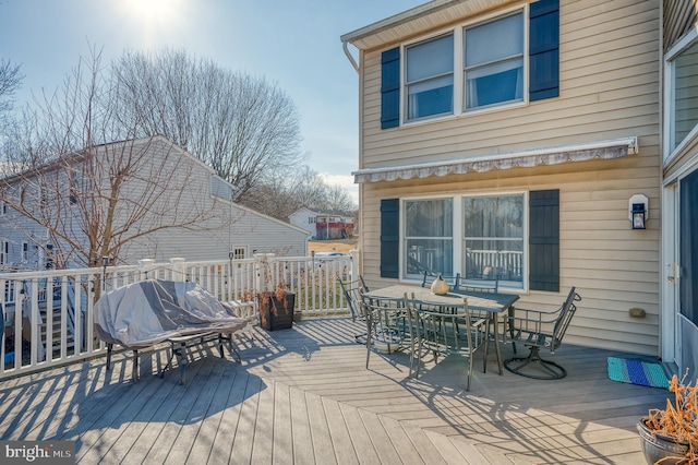 wooden terrace with outdoor dining area and grilling area