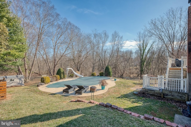 view of yard with a covered pool and a fire pit