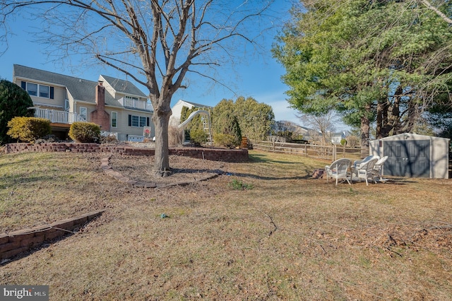 view of yard featuring fence and an outdoor structure