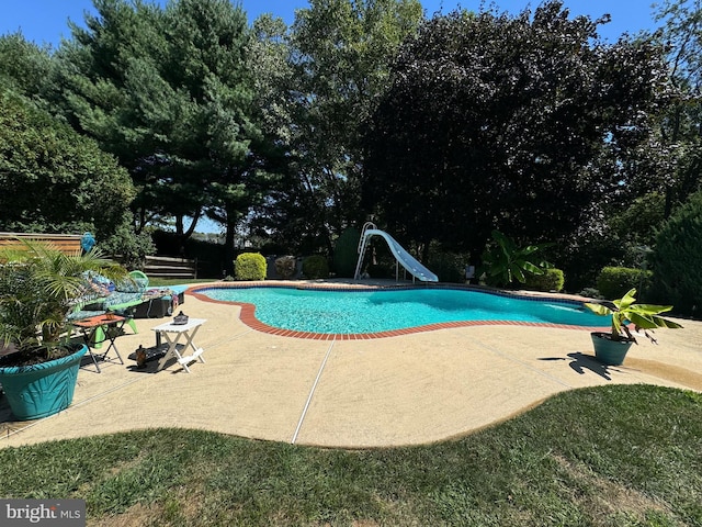 pool featuring a patio area and a water slide