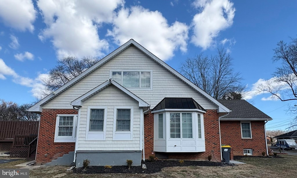 rear view of property with brick siding and a standing seam roof